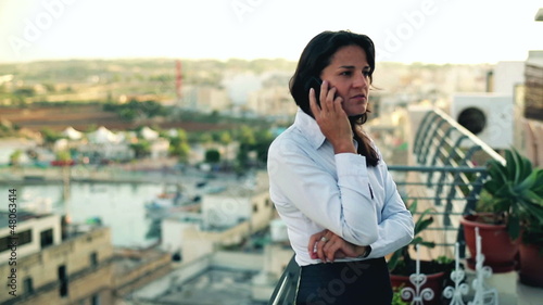 Young businesswoman talking on the cellphone on the terrace, cra photo