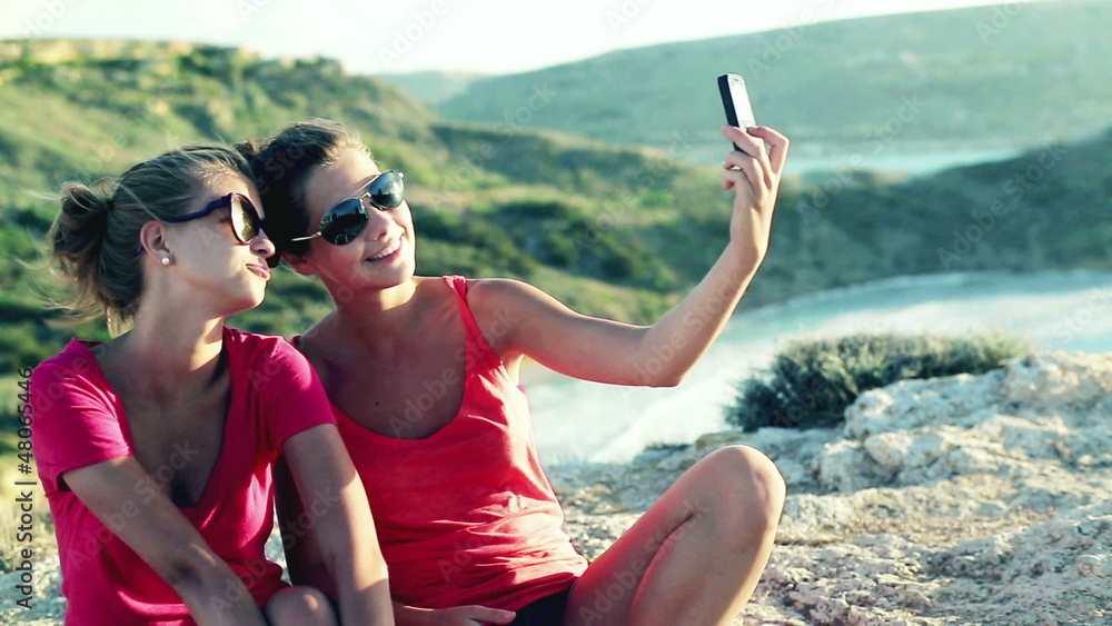 Happy women taking photo with cellphone near the vantage point Happy women taking photo with cellphone near the vantage point