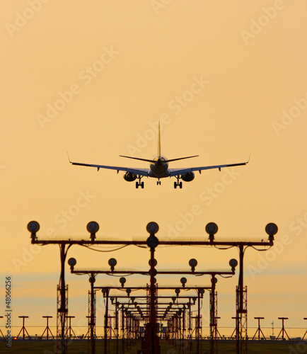 Airplane landing in sunset