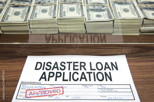 Approved disaster loan application form and dollar bills photo