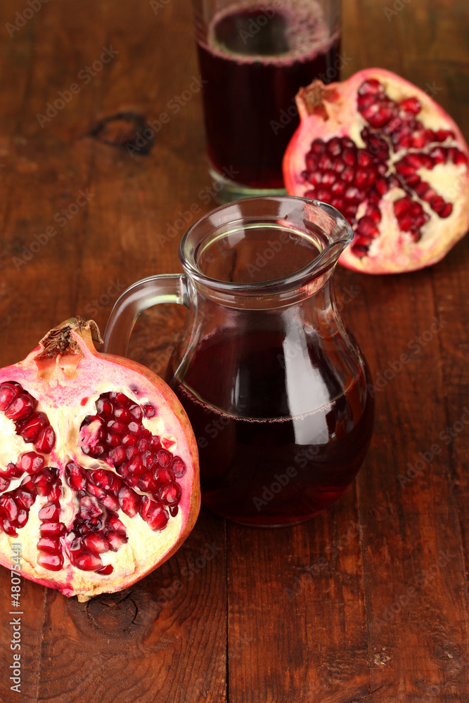 Jug with pomegranate juice,on wooden background Jug with pomegranate juice,on wooden background