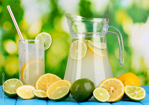 Citrus lemonade in pitcher and glass of citrus around