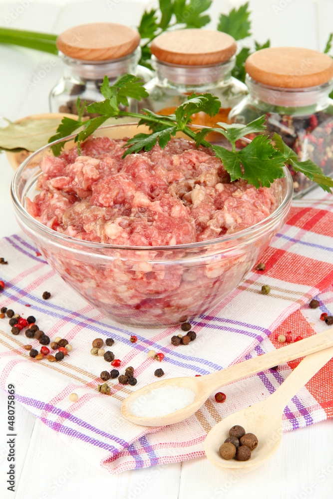 Bowl of raw ground meat with spices on wooden table Bowl of raw ground meat with spices on wooden table