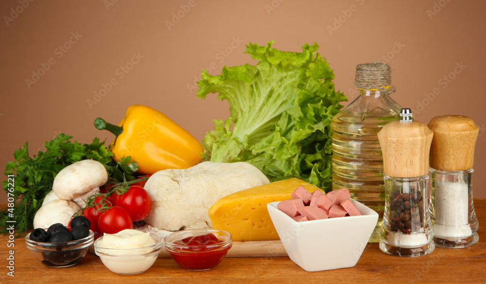 Ingredients for pizza on wooden table on brown background Ingredients for pizza on wooden table on brown background