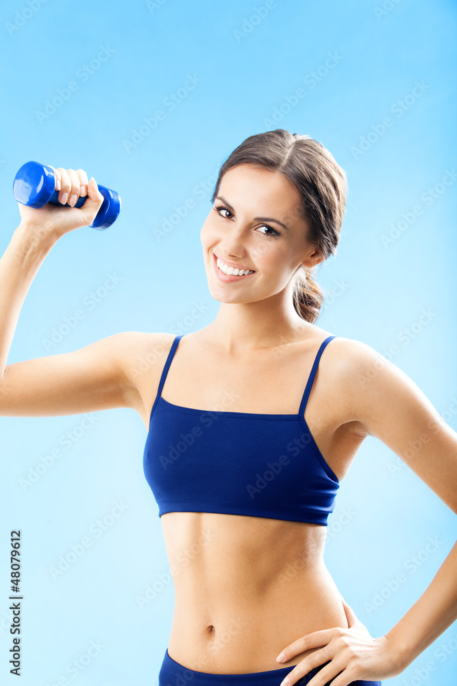 Woman in fitness wear with dumbbell, over blue Woman in fitness wear with dumbbell, over blue