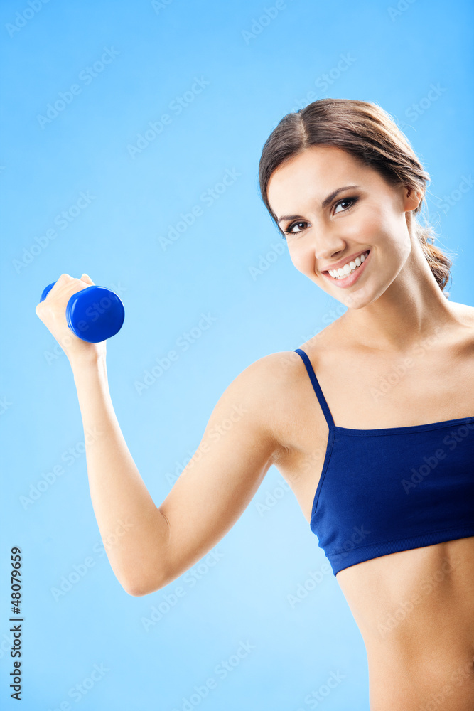 Woman in fitness wear with dumbbell, over blue Woman in fitness wear with dumbbell, over blue