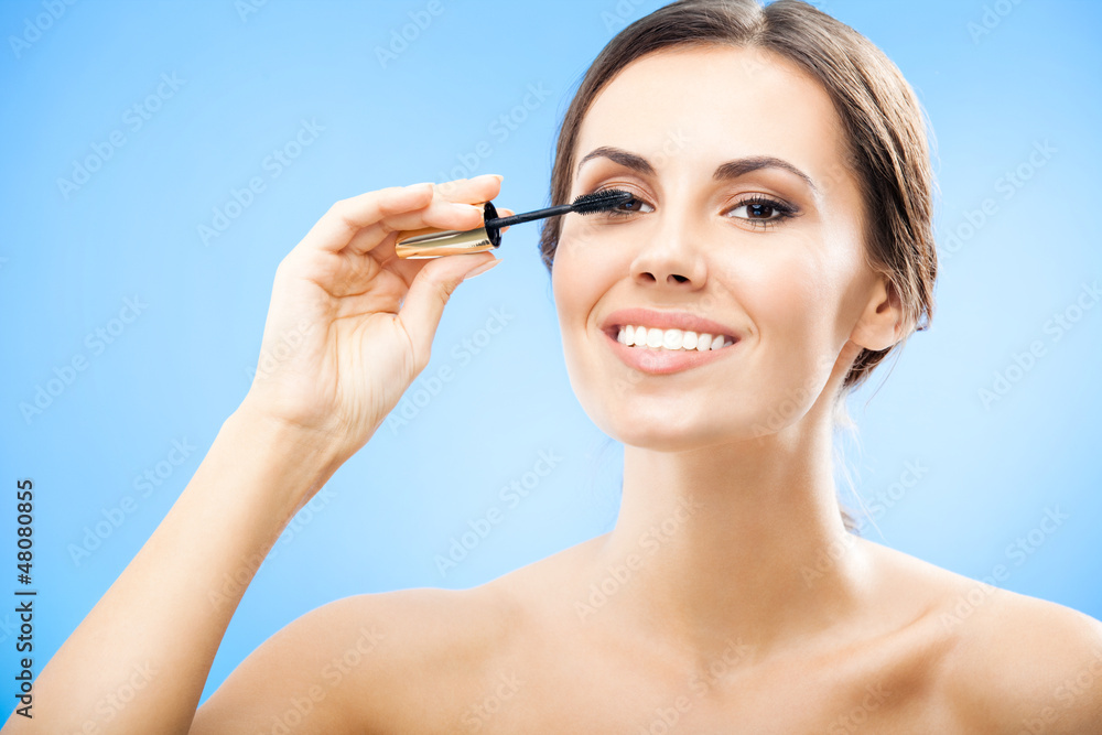Woman with cosmetics brush, on blue