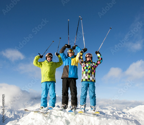 Drei Teenager mit Skistöcken nach oben