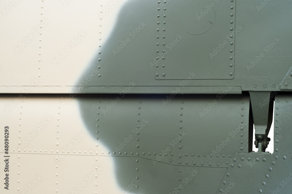 Part of fighter aircraft with camouflage color pattern.
