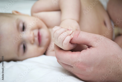A baby's hand touching an adult's hand