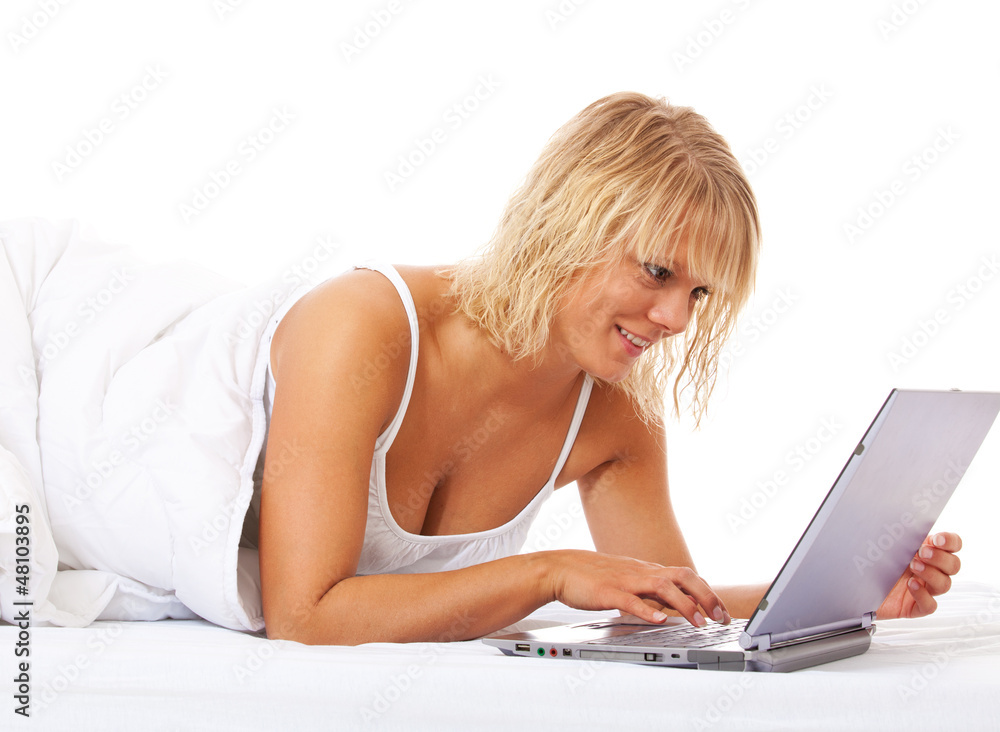 Attraktive junge Frau mit Laptop im Bett Attraktive junge Frau mit Laptop im Bett