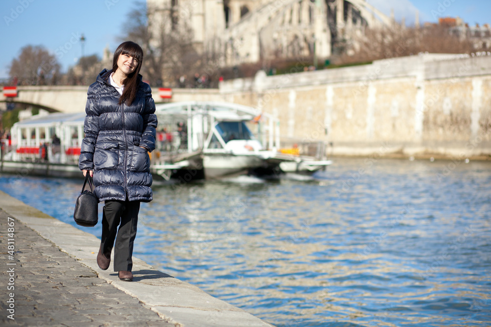 Beautiful brunette tourist walking at the emankment in Paris