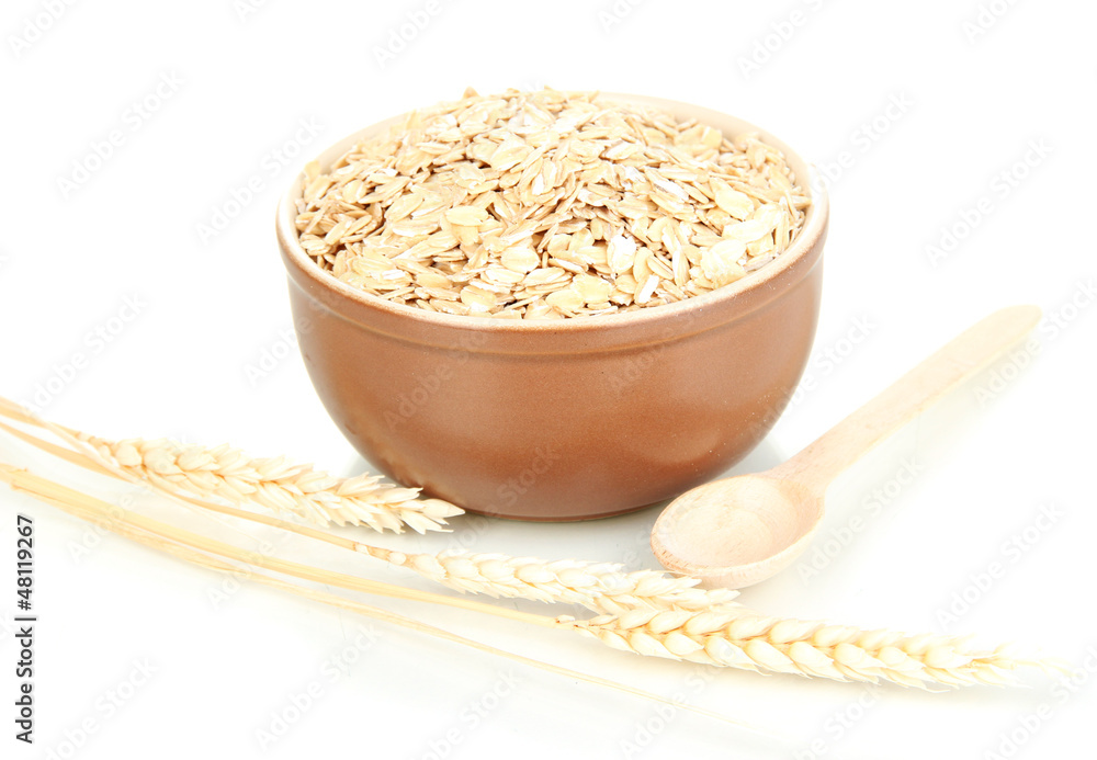 Brown bowl full of oat flakes with spikelets and wooden spoon Brown bowl full of oat flakes with spikelets and wooden spoon