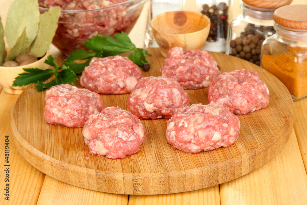 Raw meatballs with spices on wooden table Raw meatballs with spices on wooden table