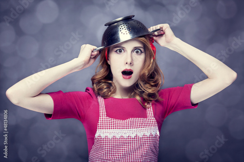 Redhead housewife with colander over head photo