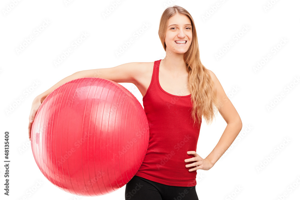 A young female athlete holding a pilates ball A young female athlete holding a pilates ball