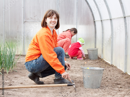 family sows seeds in soil photo