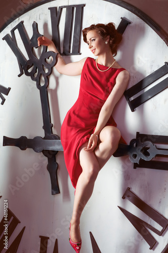 Attractive woman near Christmas tree ang huge clock