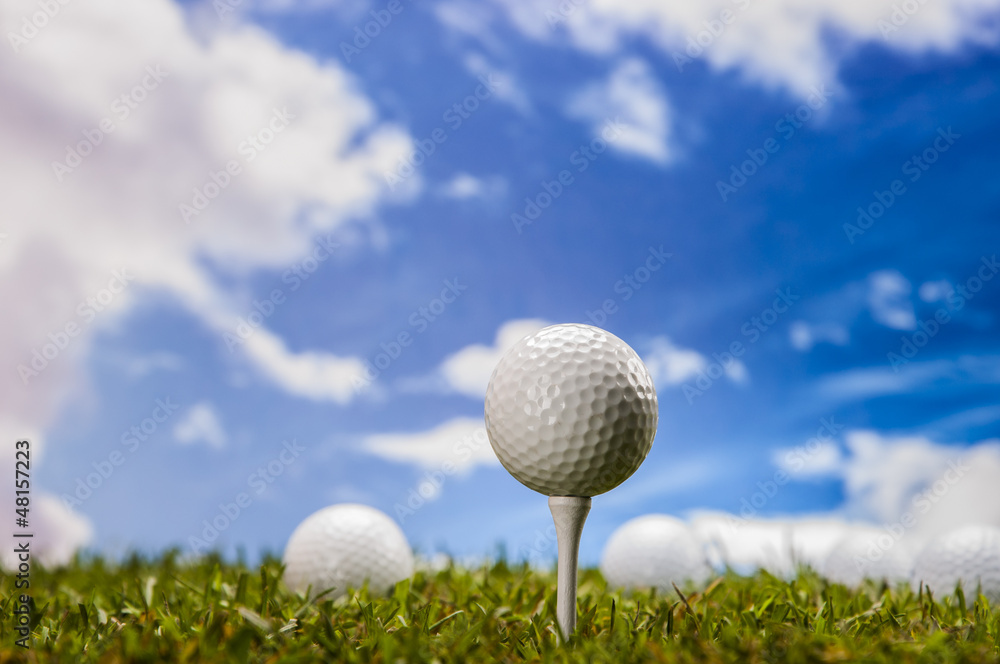 Golf balls, green grass, clouds background Golf balls, green grass, clouds background