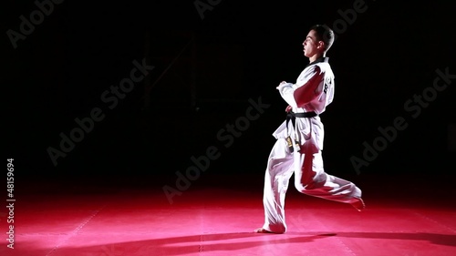 Young taekwondo athlete performing different kicks on black background