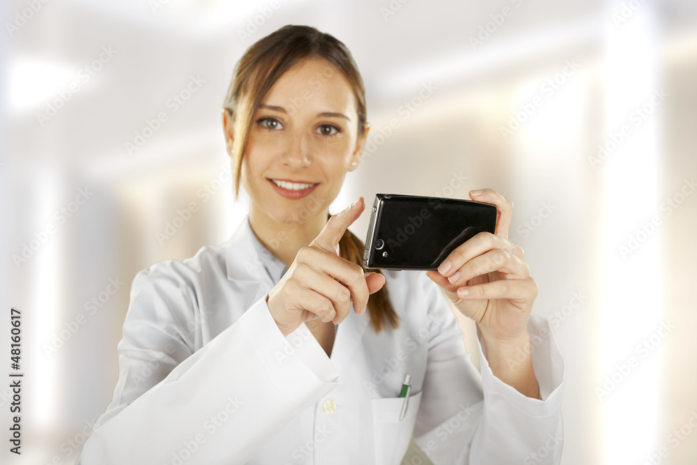 Portrait of a young smiling doctor using smartphone Portrait of a young smiling doctor using smartphone