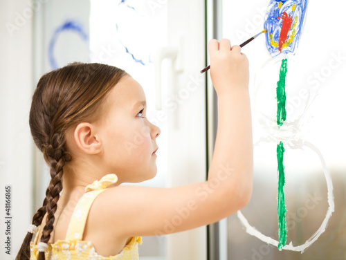 Portrait of a cute girl playing with paints photo