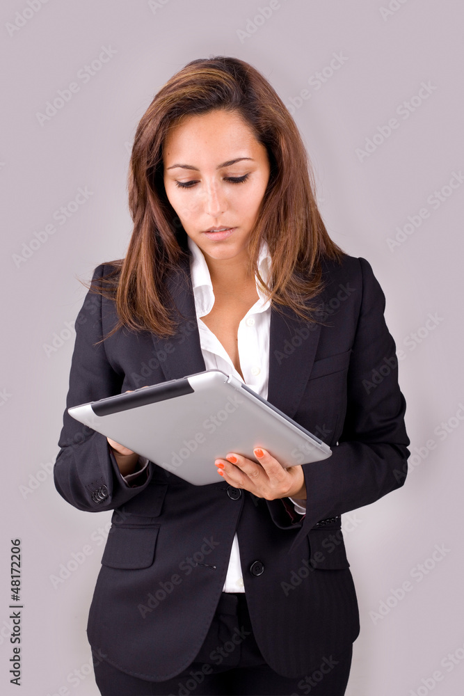 Young business woman with tablet computer on grey background Young business woman with tablet computer on grey background