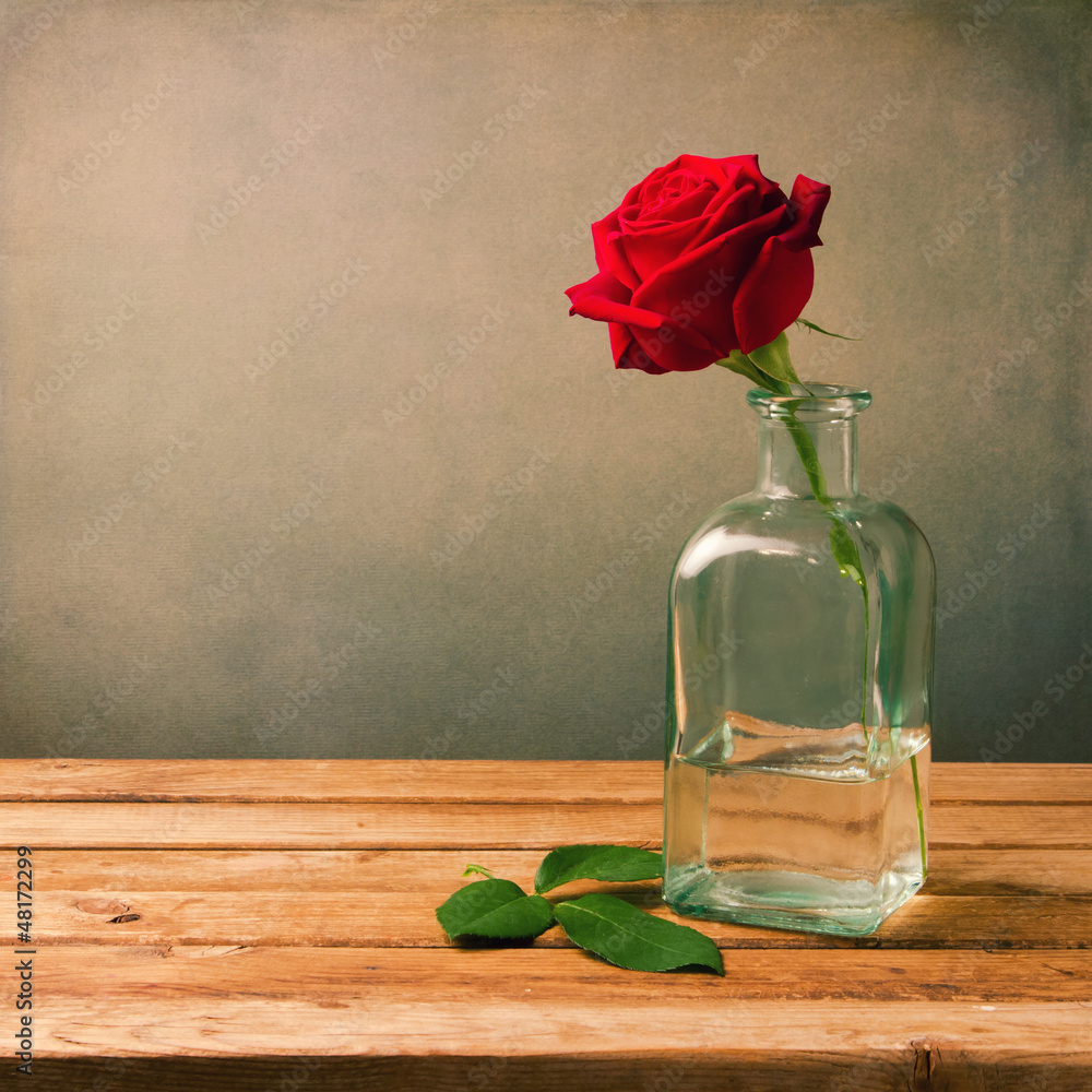 Obraz premium Red rose on wooden table