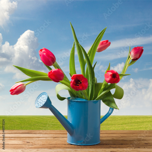 Fototapeta Naklejka Na Ścianę i Meble -  Spring tulip bouquet on wooden table over beautiful blue sky