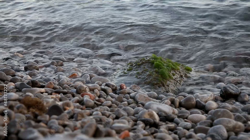 Pebble seashore with crystal clear water and waves Pebble seashore with crystal clear water and waves