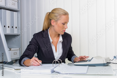 Obraz na plátně Frau im Büro mit Rechenmaschine