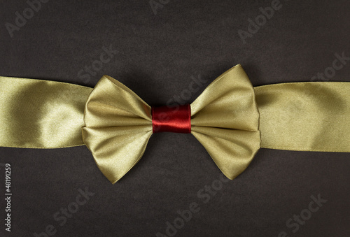 golden ribbon bow on black paper