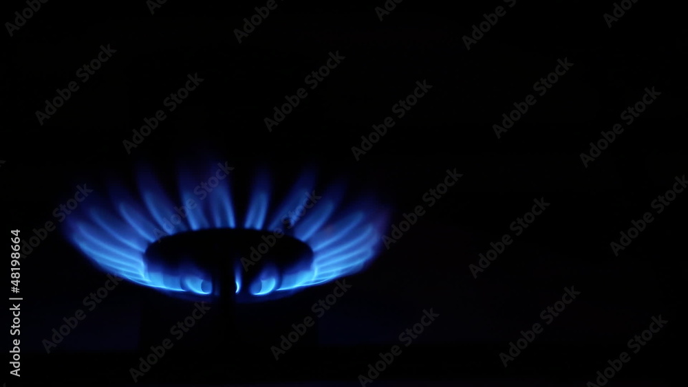 Gas stove flames ignition by match over dark background. Gas stove flames ignition by match over dark background.