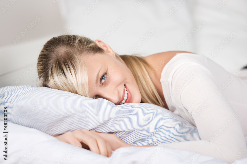 blonde frau liegt auf dem bett