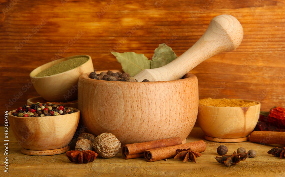mortar, bowls and spoons with spices, on wooden background mortar, bowls and spoons with spices, on wooden background