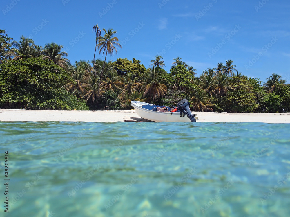 Boat landed on sandy beach shore with tropical vegetation, seen from water surface, Caribbean sea, Central America, Panama Boat landed on sandy beach shore with tropical vegetation, seen from water surface, Caribbean sea, Central America, Panama