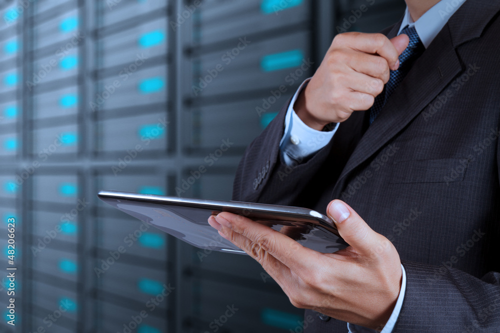 Fototapeta premium businessman hand using tablet computer and server room