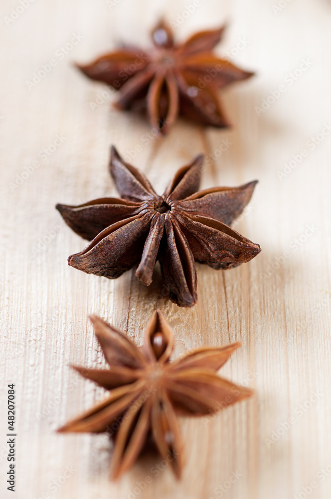 Star anise pods on a wooden board, vertical shot