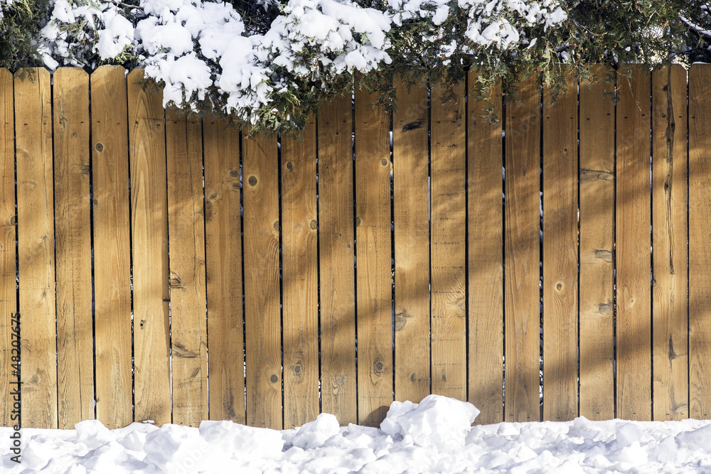 Fototapeta premium Wooden fence with snow on the top
