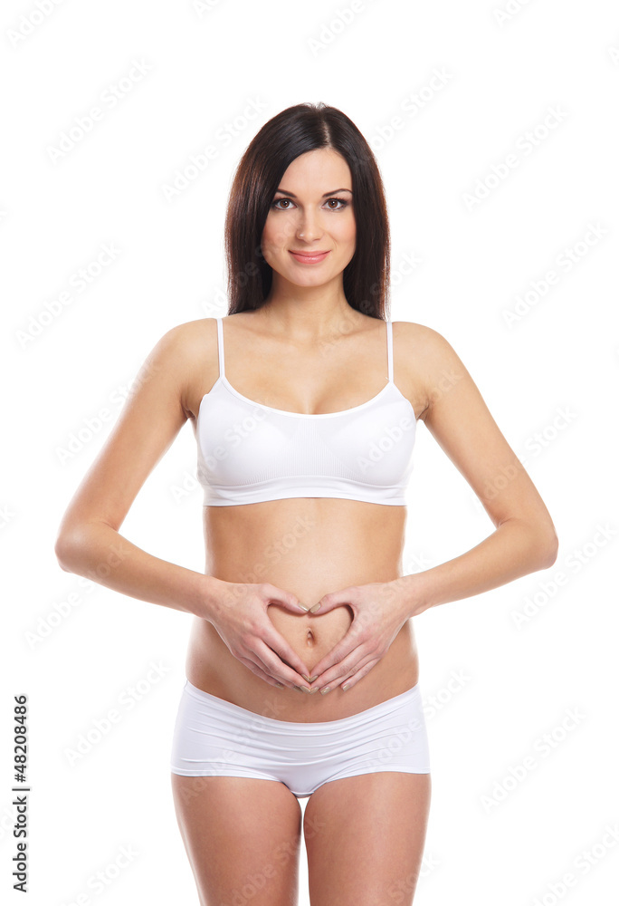 A young and happy pregnant brunett standing in white lingerie A young and happy pregnant brunett standing in white lingerie
