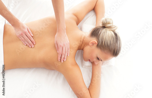 Back of a young woman relaxing on a spa massage procedure