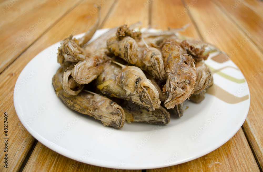 Fried fish on white dish and wood background Fried fish on white dish and wood background