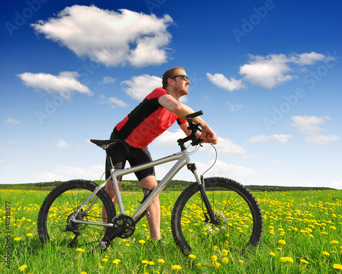 Fototapeta Naklejka Na Ścianę i Meble -  biker with the mountain bike in the dandelion field