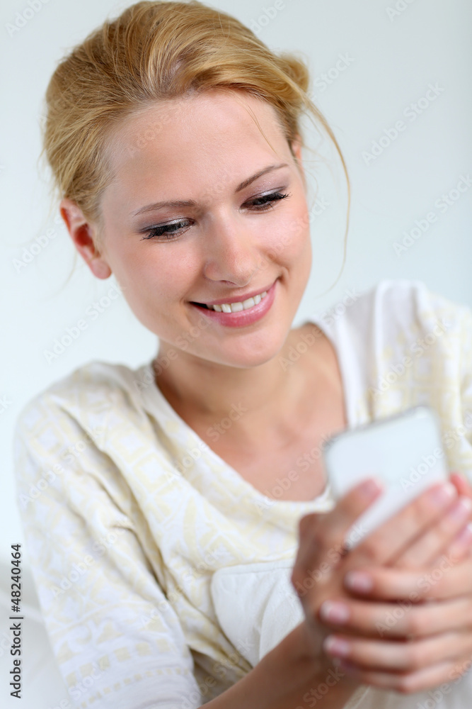 Portrait of blond girl using smartphone to send message Portrait of blond girl using smartphone to send message