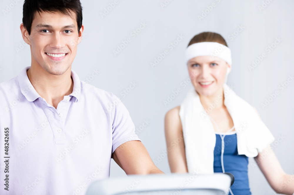 Young woman in sportswear training with coach Young woman in sportswear training with coach