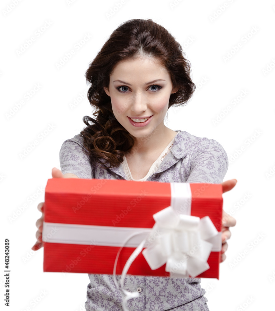 Young woman reaches out a gift wrapped in red paper Young woman reaches out a gift wrapped in red paper