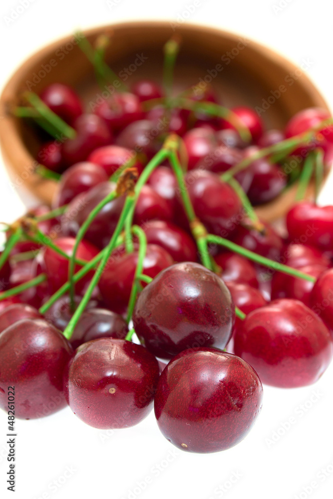 Cherry in wooden bowl isolated on white background Cherry in wooden bowl isolated on white background