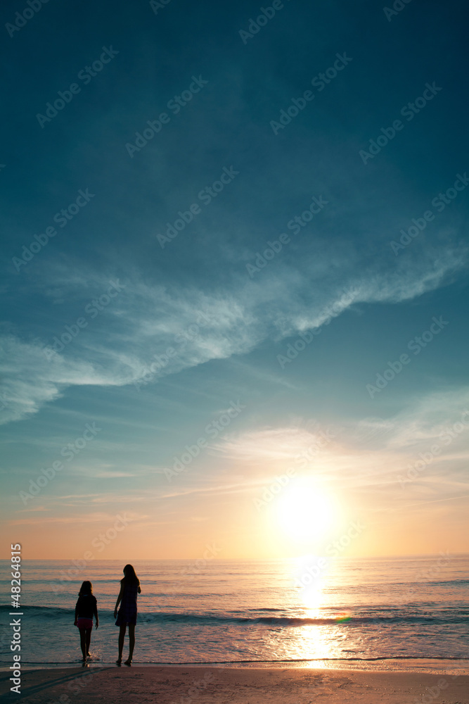 Girls on beautiful beach during sunset.