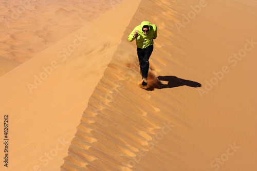 man running on sahara desert sand dunes