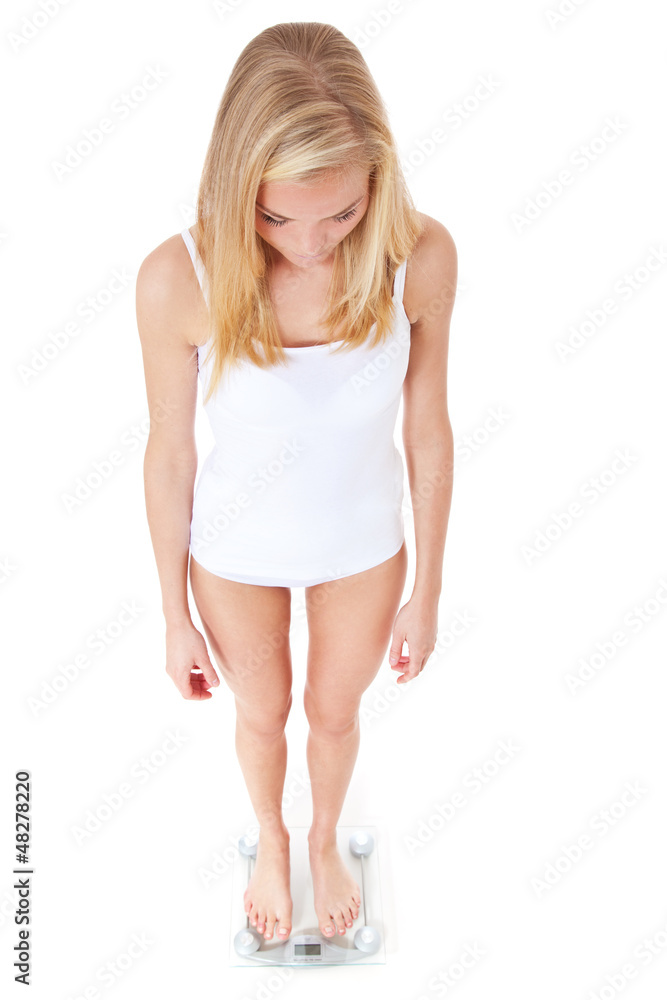 Fototapeta premium Attraktive junge Frau auf Personenwaage